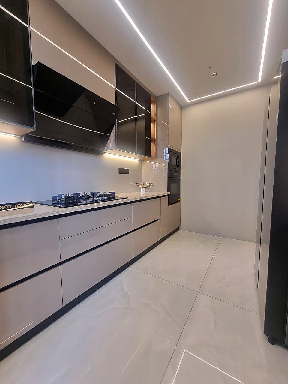 Modern modular kitchen with LED strip lighting and built-in Hafele appliances in Zirakpur luxury flat